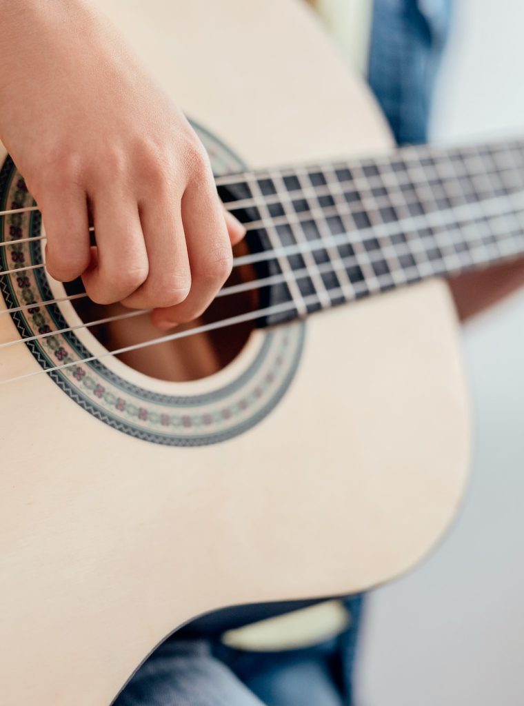 Crop kid learning to play guitar